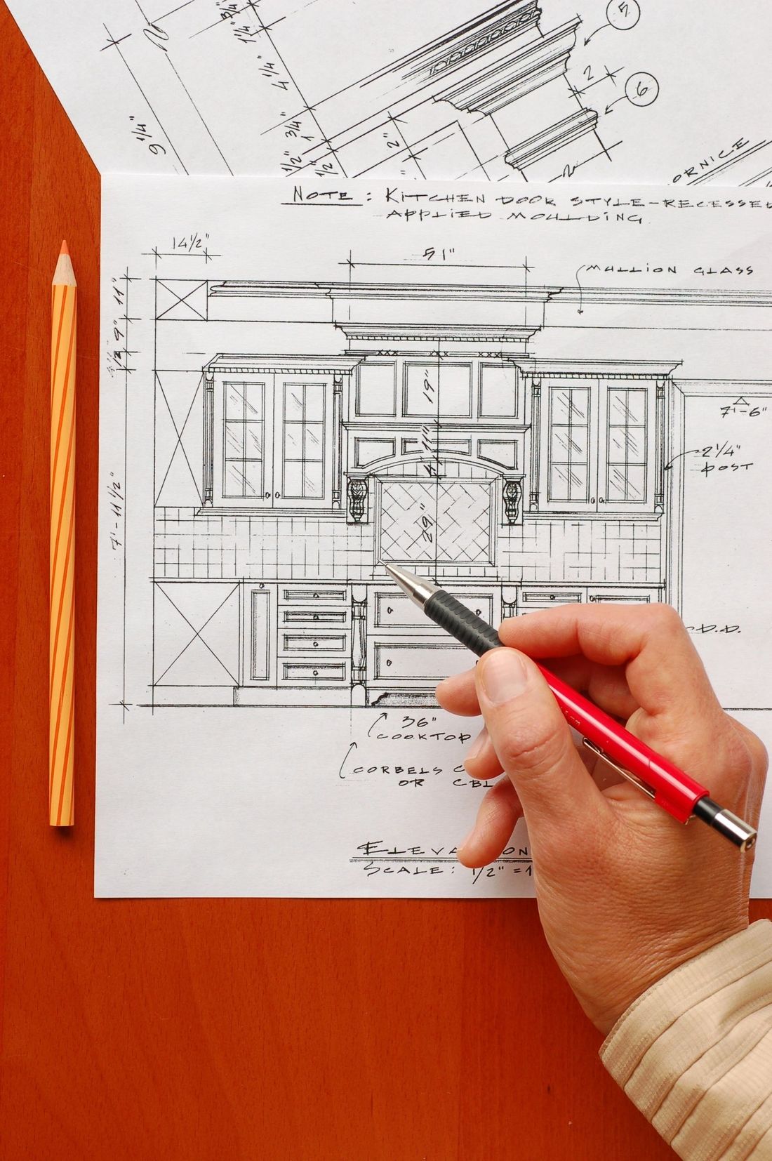 Hand sketching a kitchen blueprint with a pencil