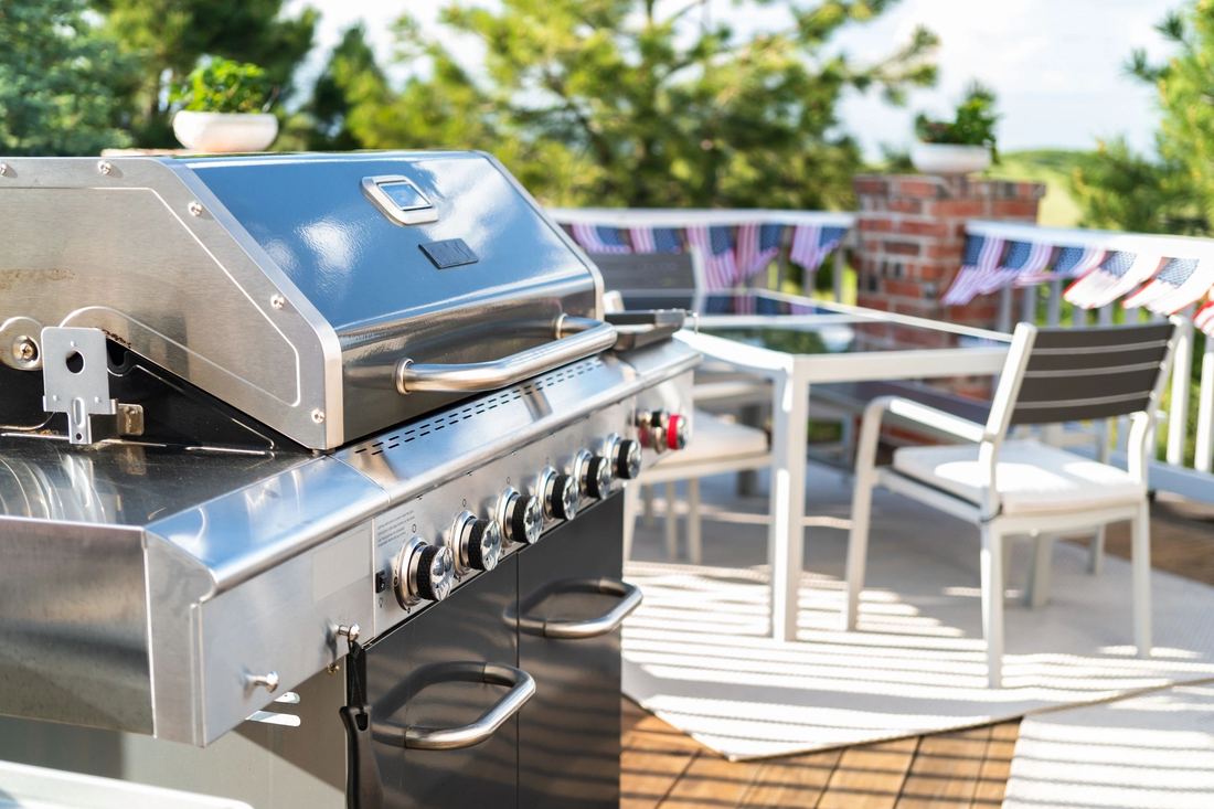 Family gathered around an outdoor grill and patio